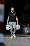 Hyscon medewerker tilt schoonmaakmiddelen voor levering aan klanten